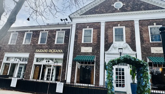 Brick building exterior with white trim and green awnings at Shaker Square